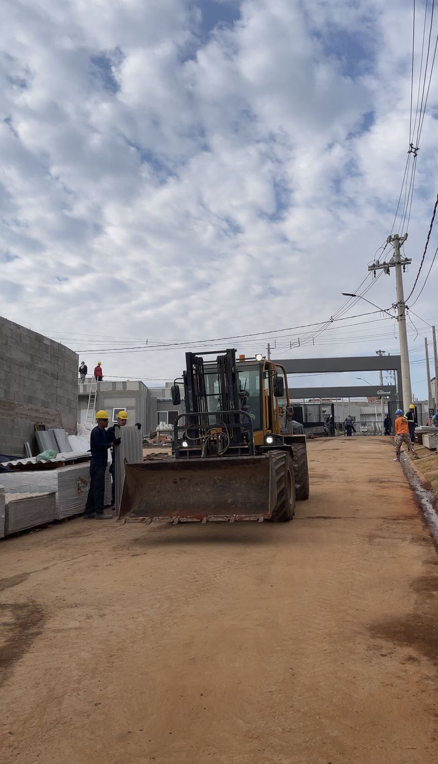 Máquina com carga na rua de acesso do condomínio.