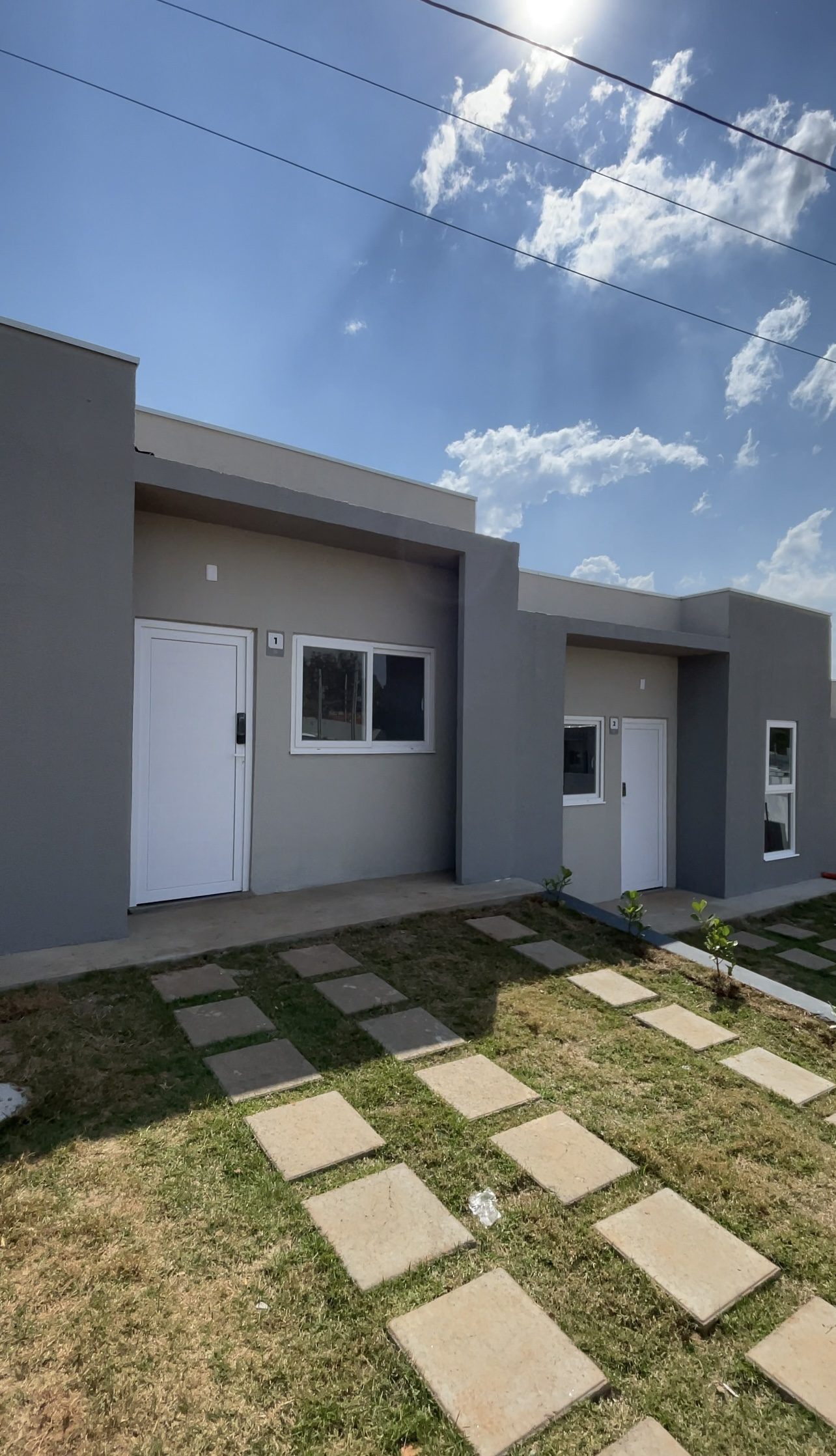 Casas entregues do Di Napoli II, com gramado e caminho de placas até a porta.